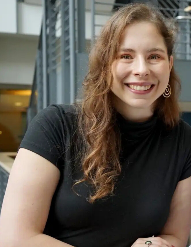 A headshot of Sierra Grandy, a white woman in a black turtleneck