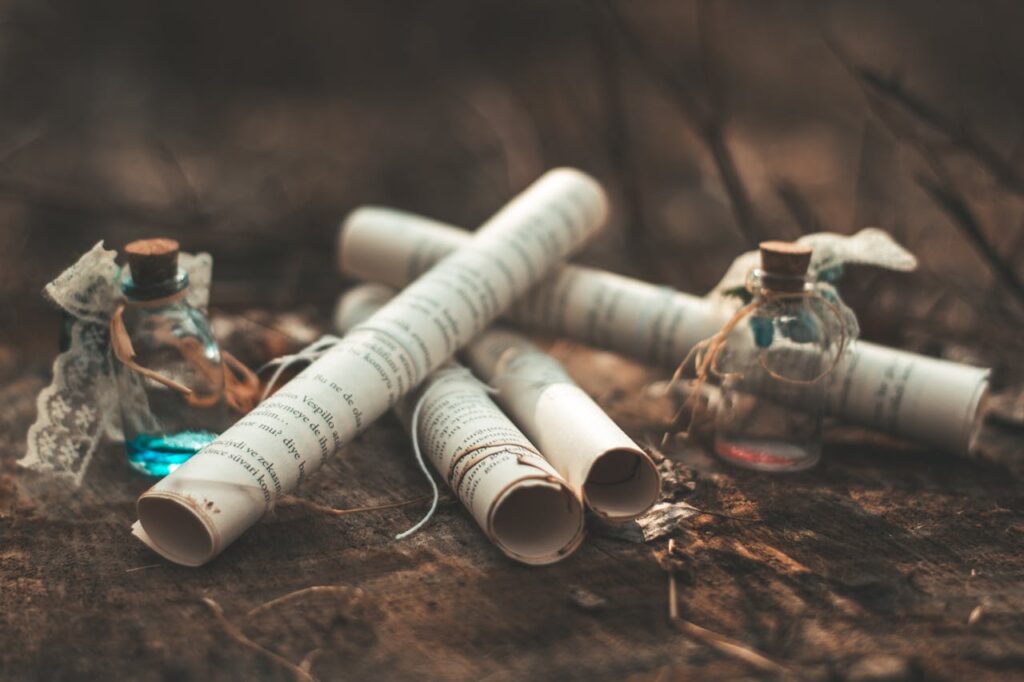 Artistic display of scrolls and potion bottles on earthy surface, evoking a sense of mystery.